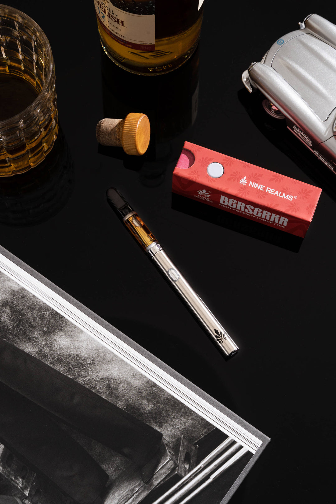 Vape-Pen und „Nine Realms Berserkr“-Kartusche auf einer schwarzen Oberfläche