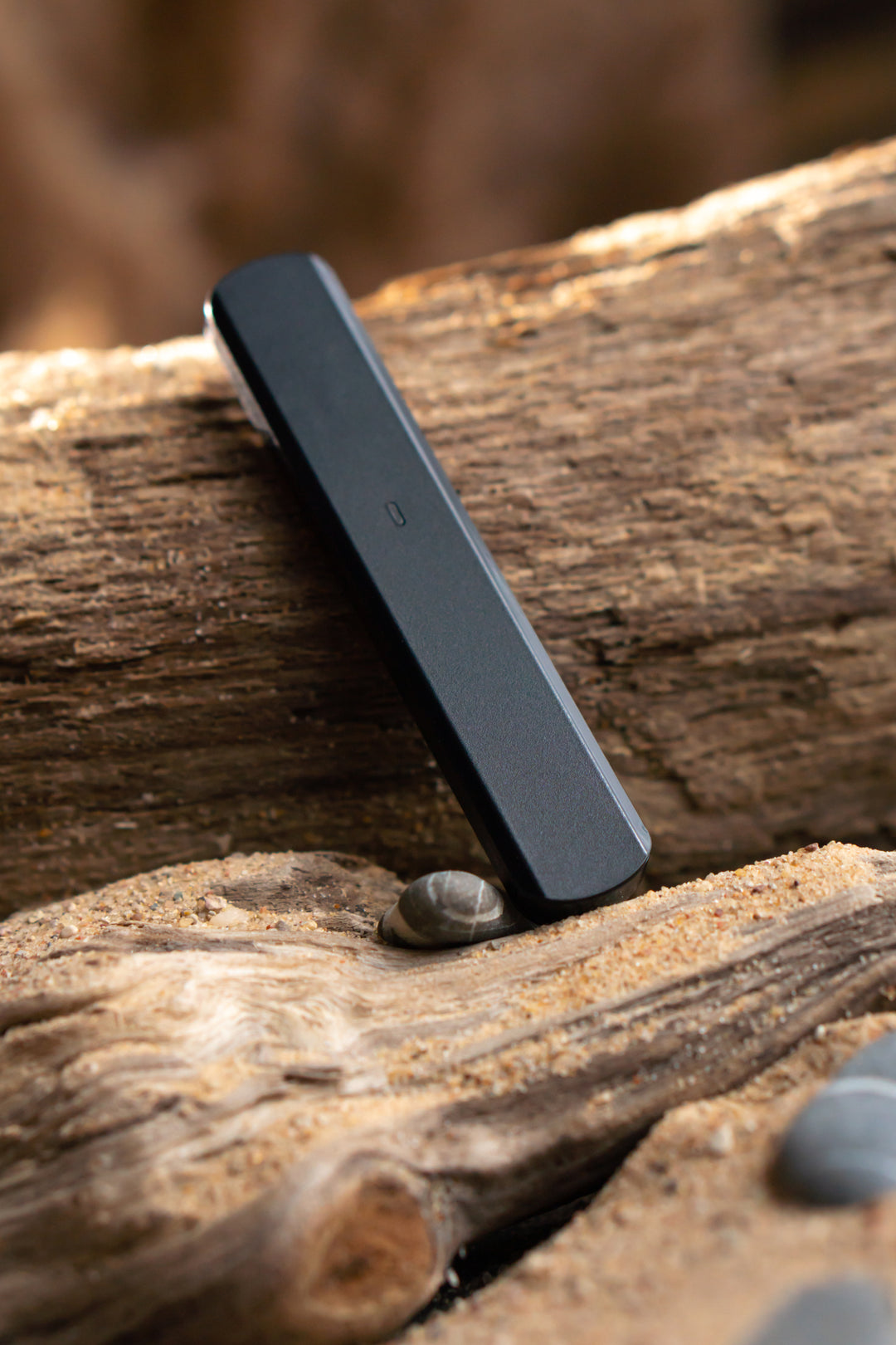 a premium nine realms vape displayed in an artistic setting, on a natural wooden log