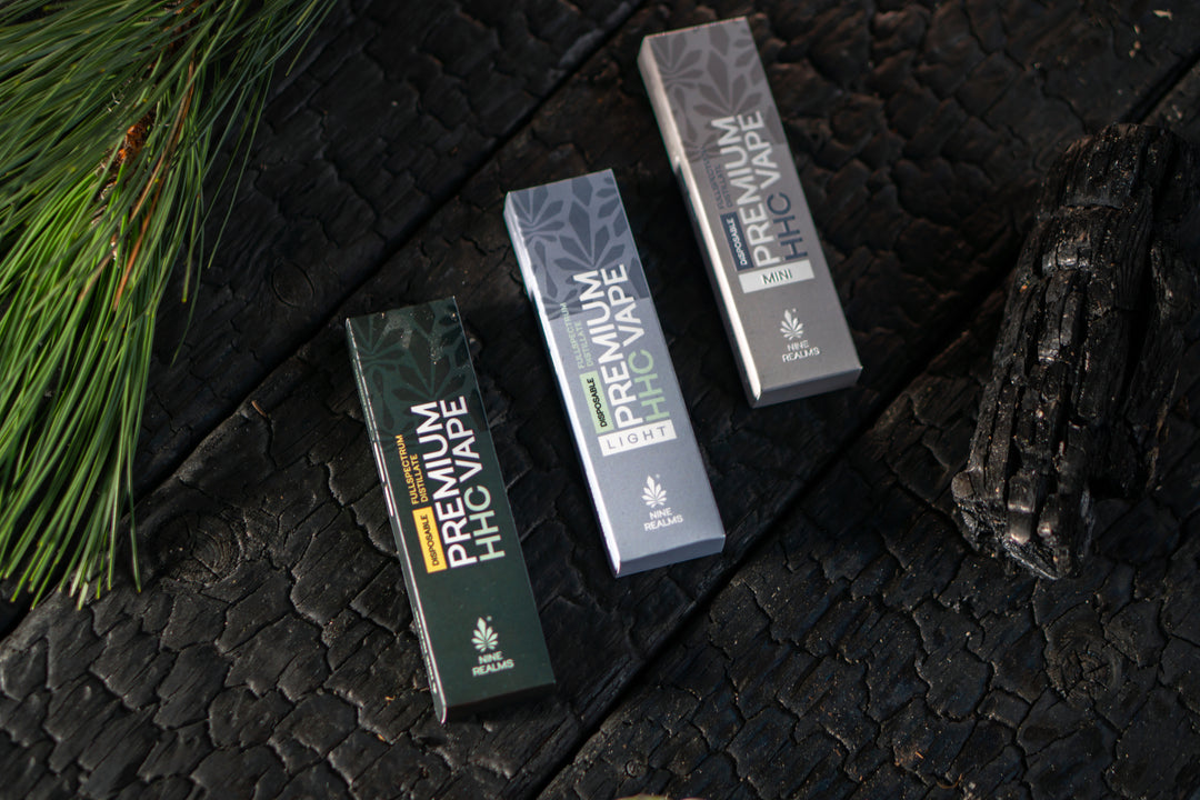 Nine Realms Disposable Vapes on charocal board and spruce needles