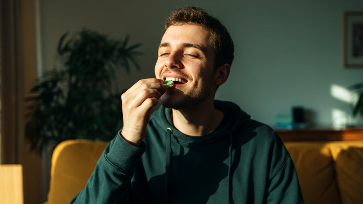 Man enjoying nine realms cannabis gummies in the living room