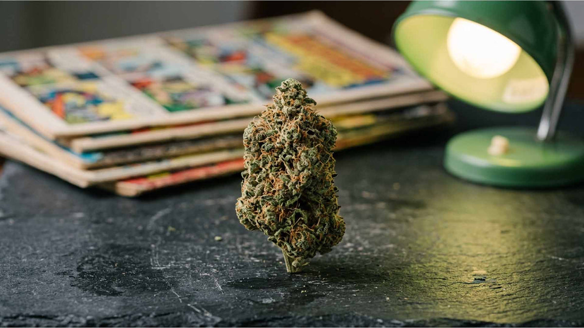 Bruce Banner strain from Nine Realms next to a green lamp and comic books