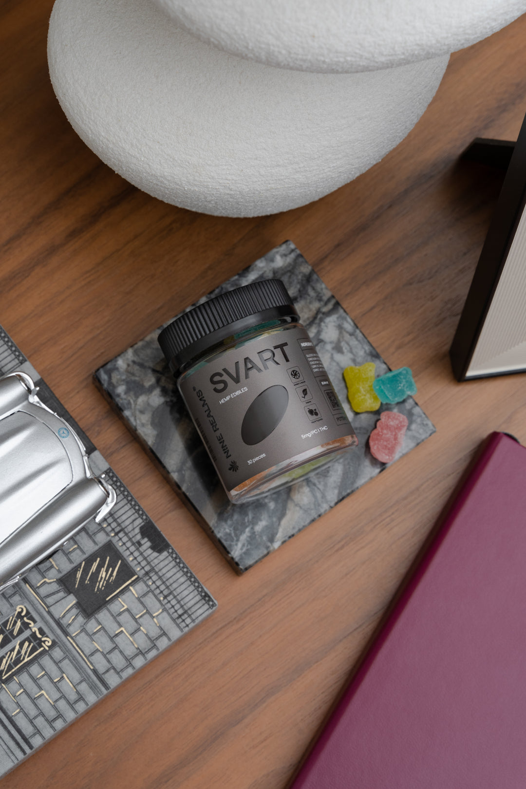 Nine Realms THC Gummies SVART on the table with notebook