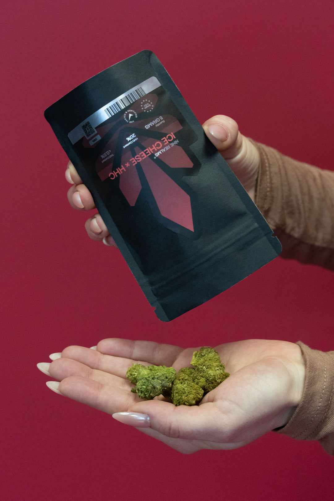 Female holding weed doypack with cannabis flower buds and red background