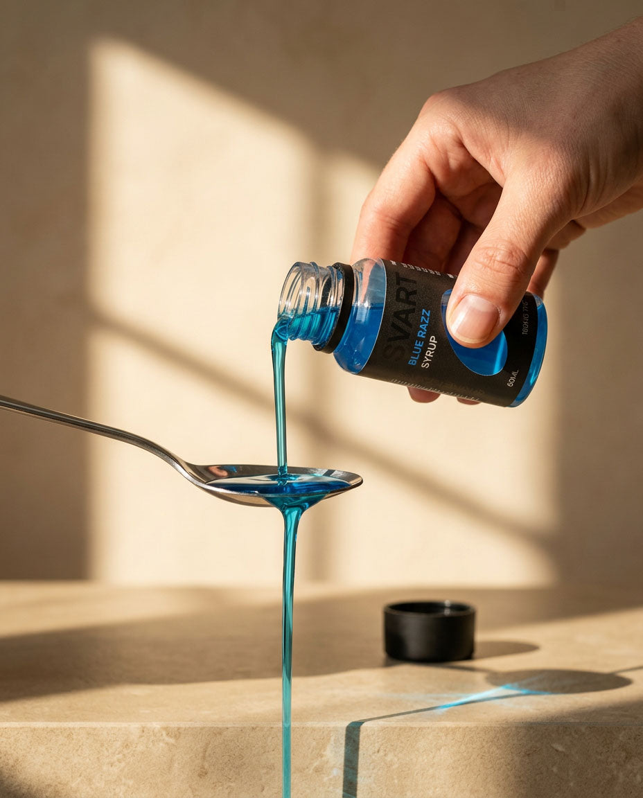 A hand holds a small bottle of Nine Realms SVART THC Syrup, pouring a thick blue liquid onto a metal spoon over a beige stone surface with warm sunlight and shadows.