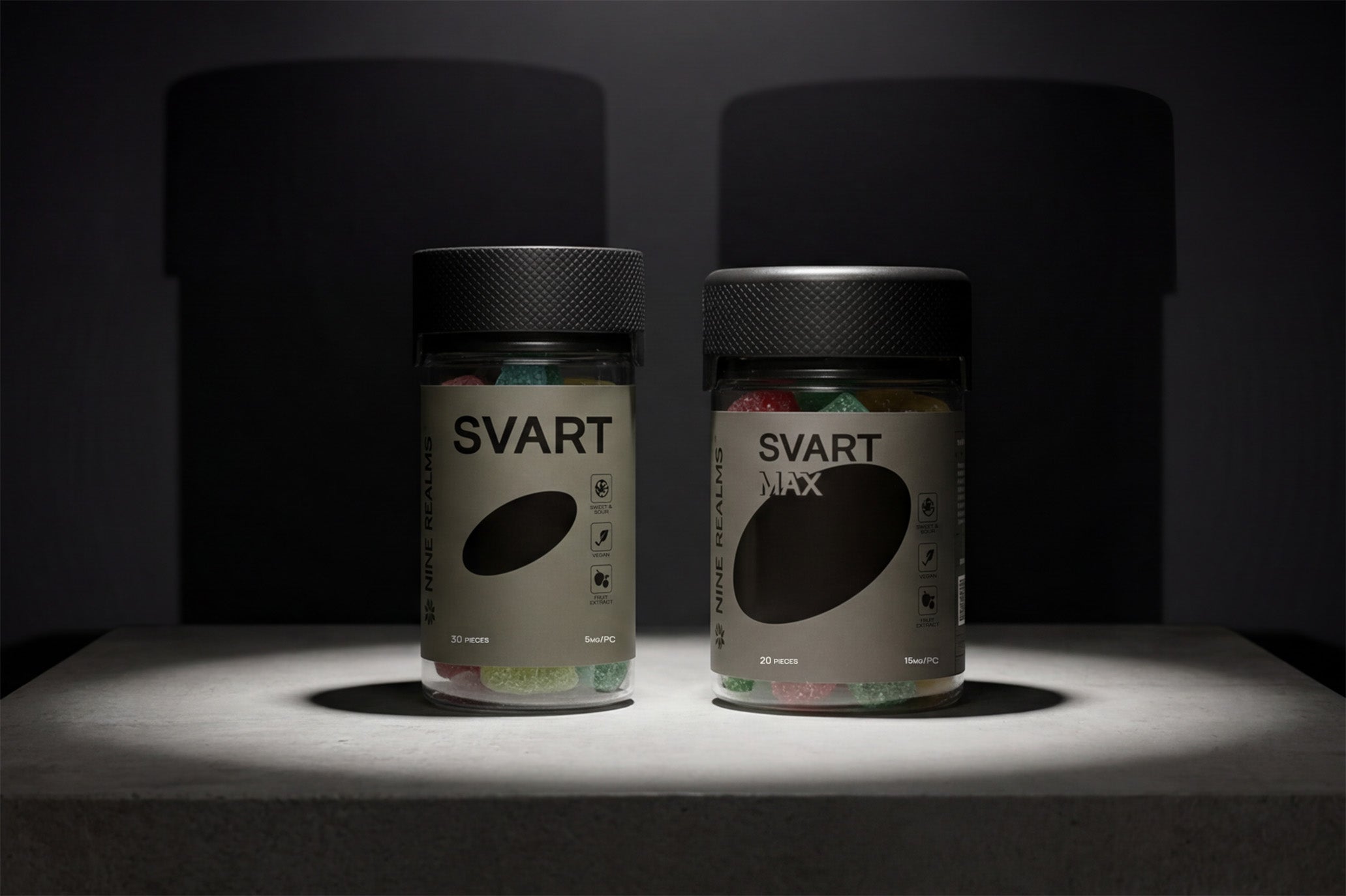 Two jars of Nine Realms THC gummies on a stone block, SVART and SVART MAX
