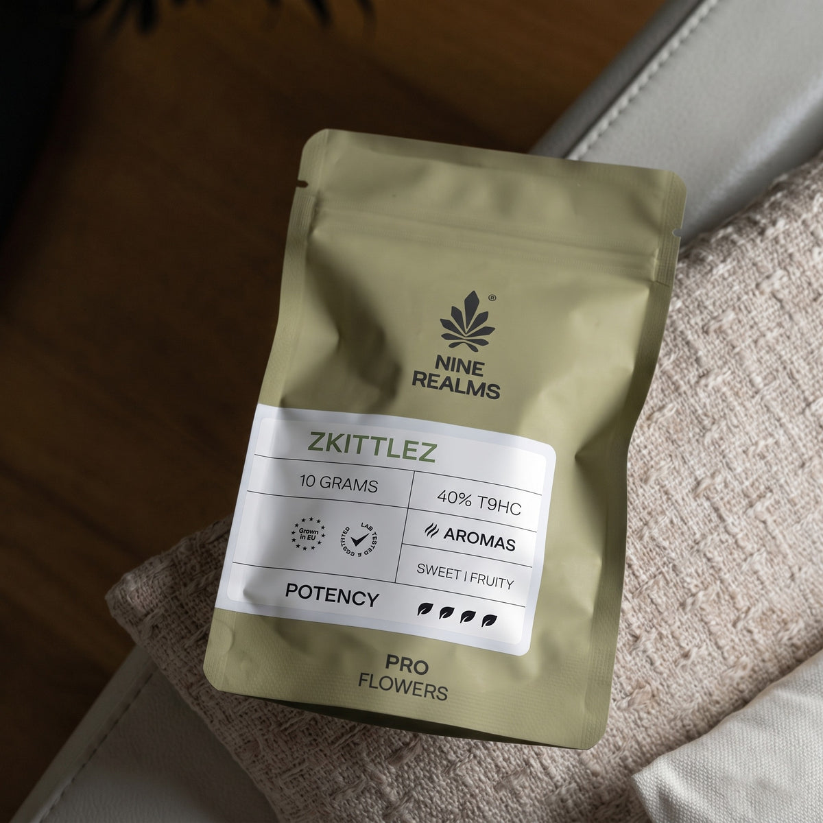 Nine Realms Zkittlez T9HC flowers, 10g PRO pouch on a sofa cushion